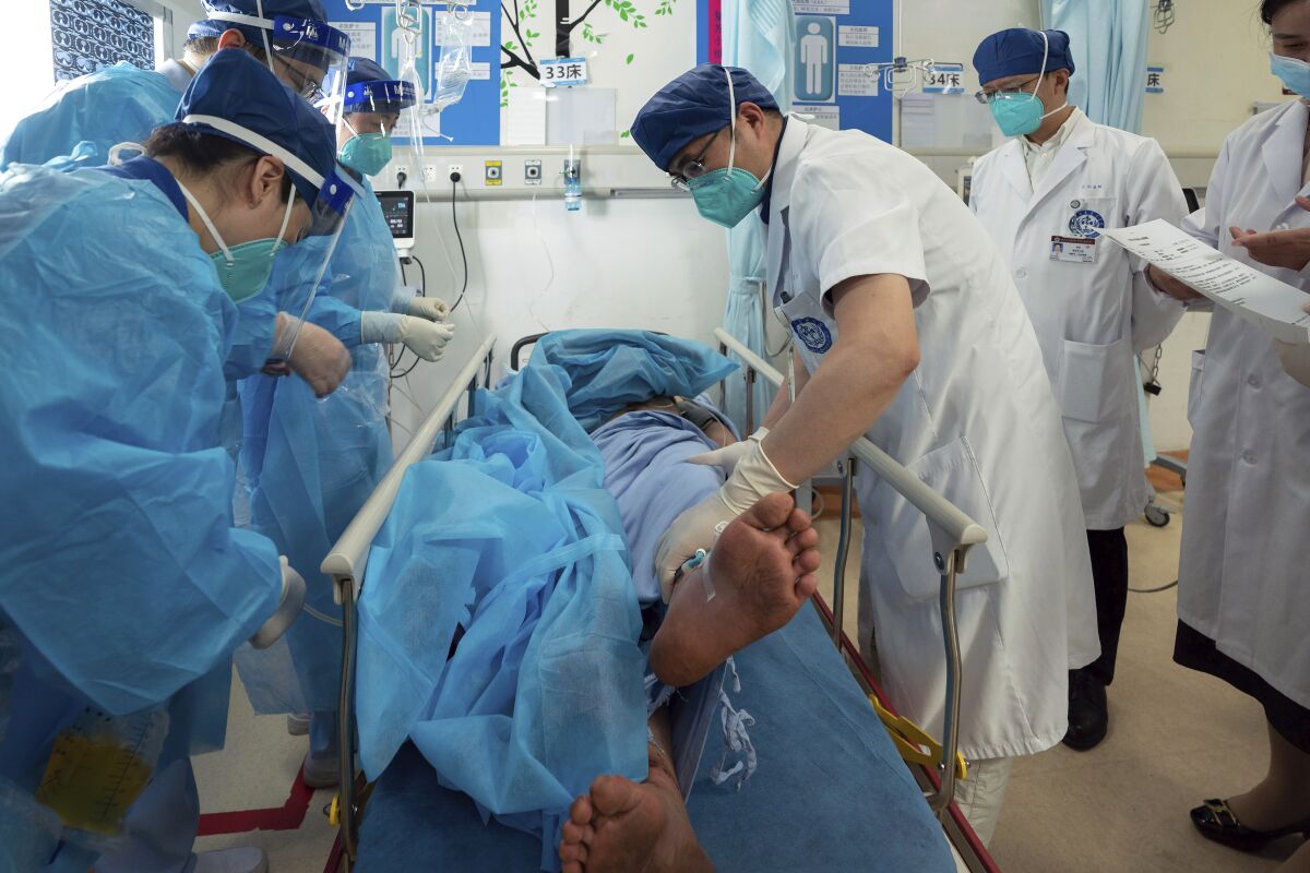 In this photo released by Xinhua News Agency, medical workers check the health condition of Gan Yu, a hydropower station worker who had gone missing for 17 days after an earthquake, at the West China Hospital of Sichuan University in Chengdu, capital of southwest China's Sichuan Province, Sept. 21, 2022 (Xinhua via AP)