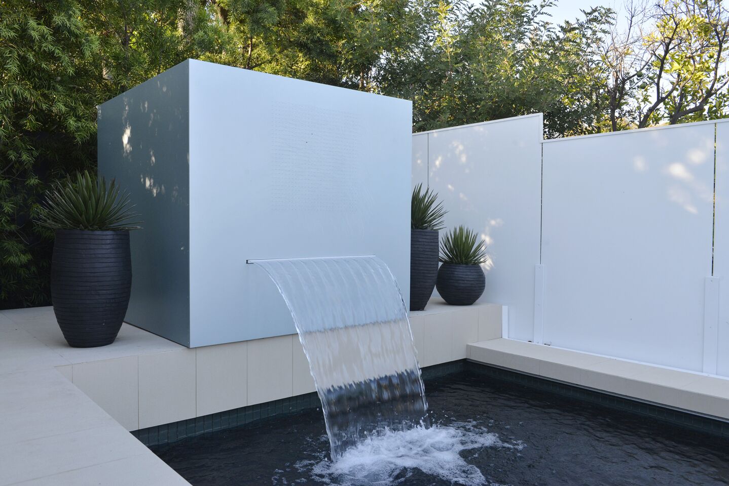 The fountain cube is an aluminum-covered concrete masonry unit.