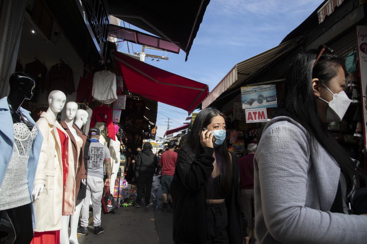 Masked shoppers navigate Santee Alley in downtown Los Angeles. 