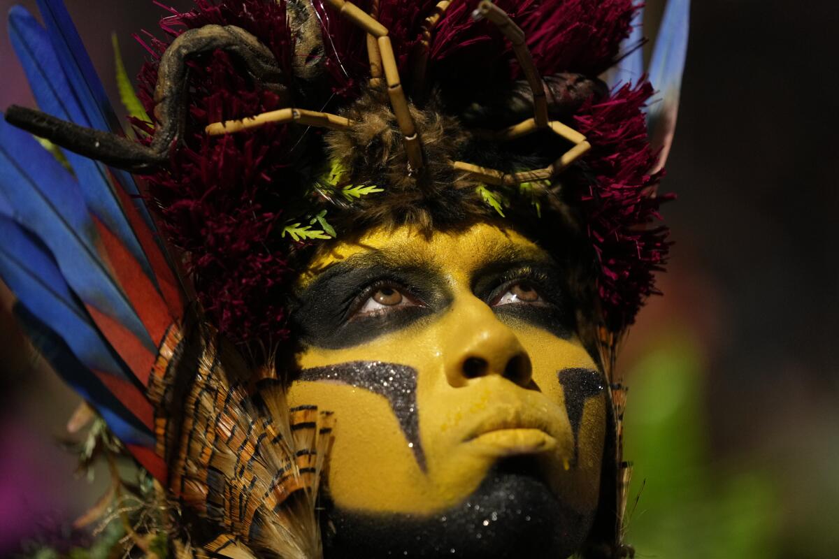 A performer wearing face paint and costume parades during Carnival