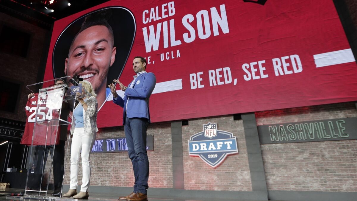 Tennessee Titans kicker Ryan Succop, right, announces the final pick of the NFL football draft Saturday in Nashville, Tenn. UCLA tight end Caleb Wilson, picked by the Arizona Cardinals, is this year's "Mr. Irrelevant."