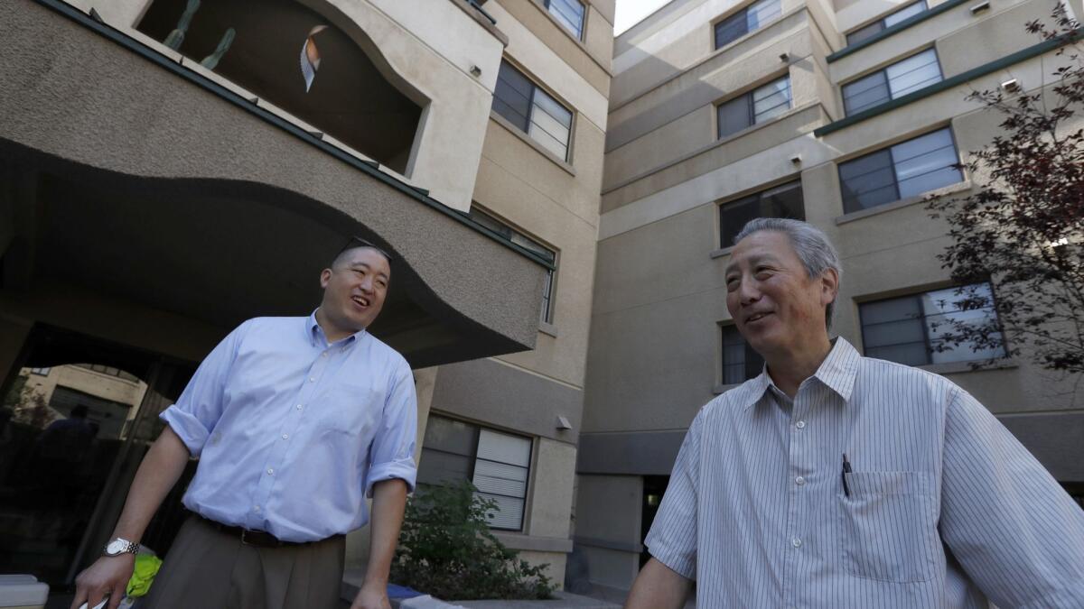 Grant Sunoo, left, and Erich Nakano, executives with the Little Tokyo Service Center, stand in the courtyard of an affordable housing project at Casa Heiwa in Little Tokyo.