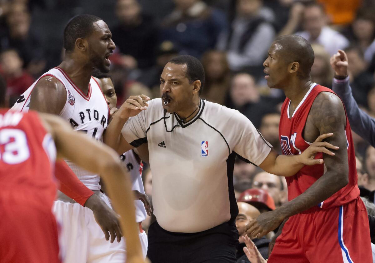 Referee Bennie Adams separates Clippers guard Jamal Crawford (right) and Raptors forward Patrick Patterson during the first half.