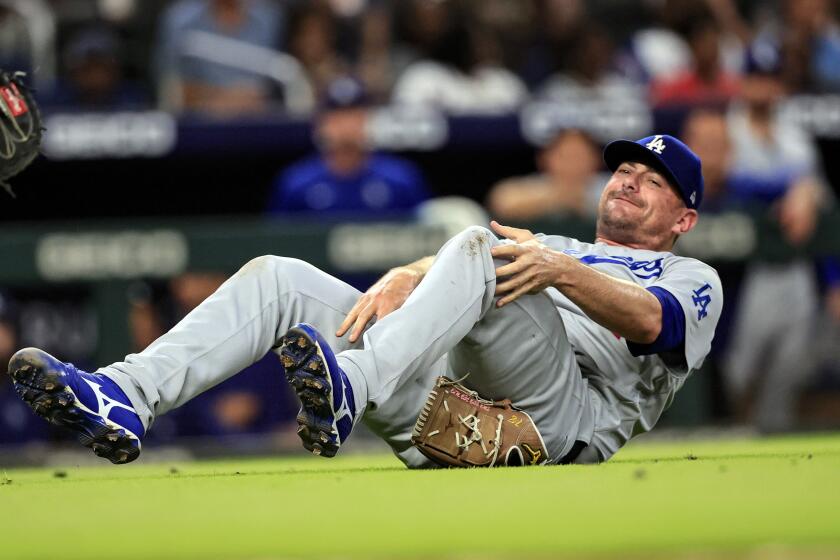 Los Angeles Dodgers relief pitcher Daniel Hudson falls to the ground with an injury during the eighth inning of a baseball game against the Atlanta Braves Friday, June 24, 2022, in Atlanta. (AP Photo/Butch Dill)