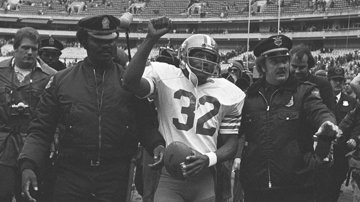 San Francisco 49ers running back O.J. Simpson is escorted from the field by police after the final NFL game of his career. (Associated Press )