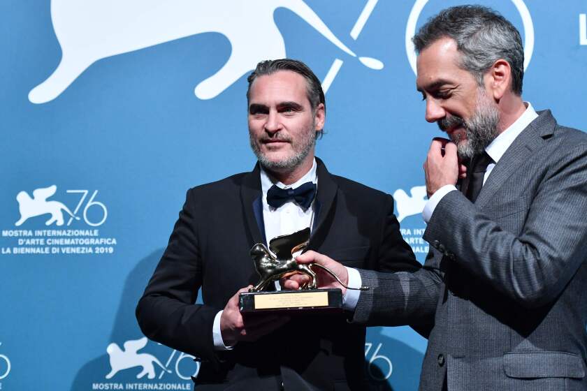 El director Todd Phillips (d) y el actor Joaquin Phoenix reciben el premio principal en el Festival de Cine de Venecia.