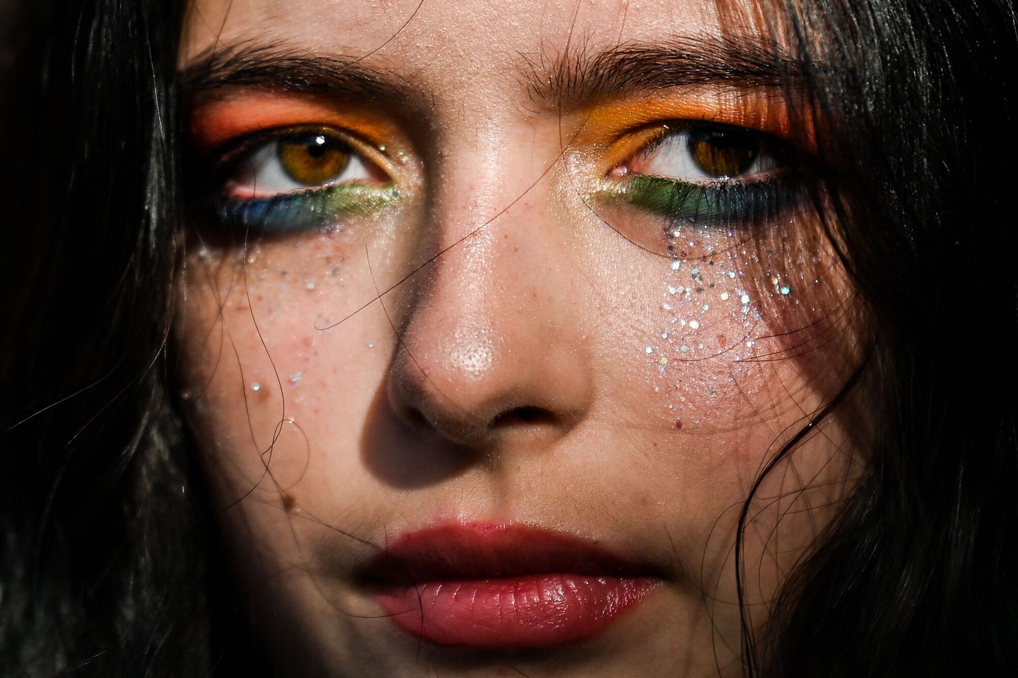 A person with rainbow-colored eye makeup.