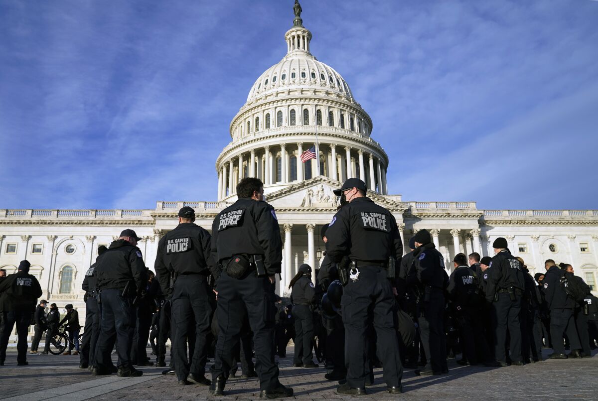 FILE - A large group of police arrive at the Capitol, Jan. 6, 2022, in Washington. A U.S. Capitol Police officer fired a gun inside a break room in a House office building on Tuesday and was promptly suspended — the latest stain for a police department struggling to regain the public's trust following the deadly Jan. 6 insurrection and a recent communications failure that triggered an evacuation. (AP Photo/Evan Vucci, File)