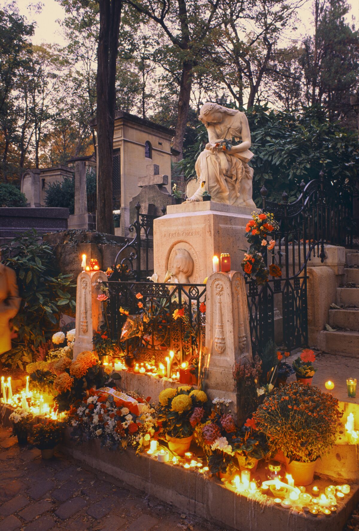 “City of Immortals” includes the tomb of composer Frédéric Chopin, pictured at dusk on All Souls’ Day. 