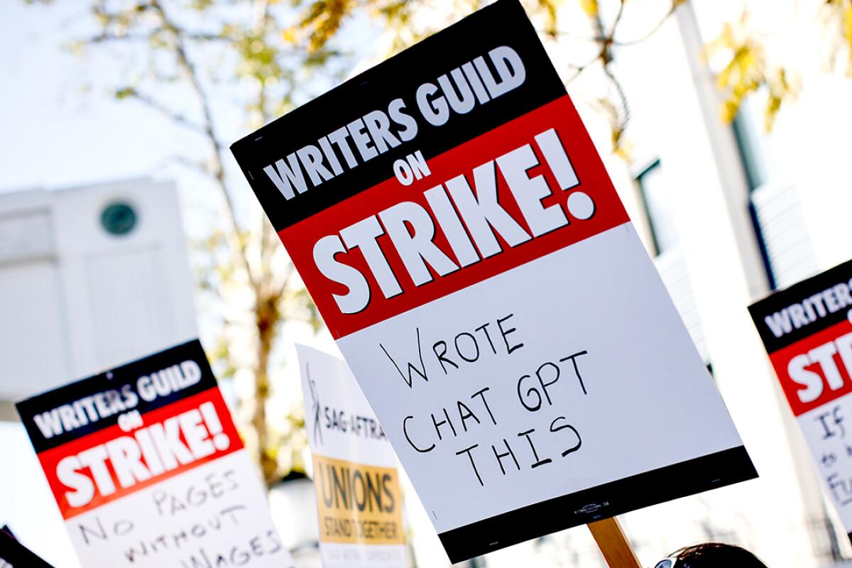 A WGA striker's picket sign reads: Wrote ChatGPT this