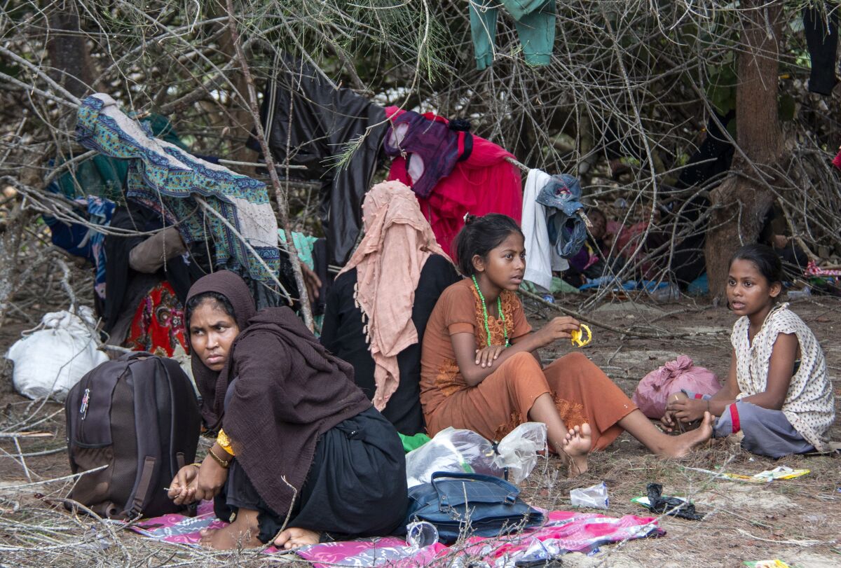 Ethnic Rohingya people rest on a beach after their boat was stranded on Idaman Island in East Aceh, Indonesia, Friday, June 4, 2021. Villagers in Indonesia's Aceh province discovered a stranded boat carrying dozens of Rohingya Muslims, including children, who had left a refugee camp in Bangladesh, officials said. (AP Photo/Zik Maulana)