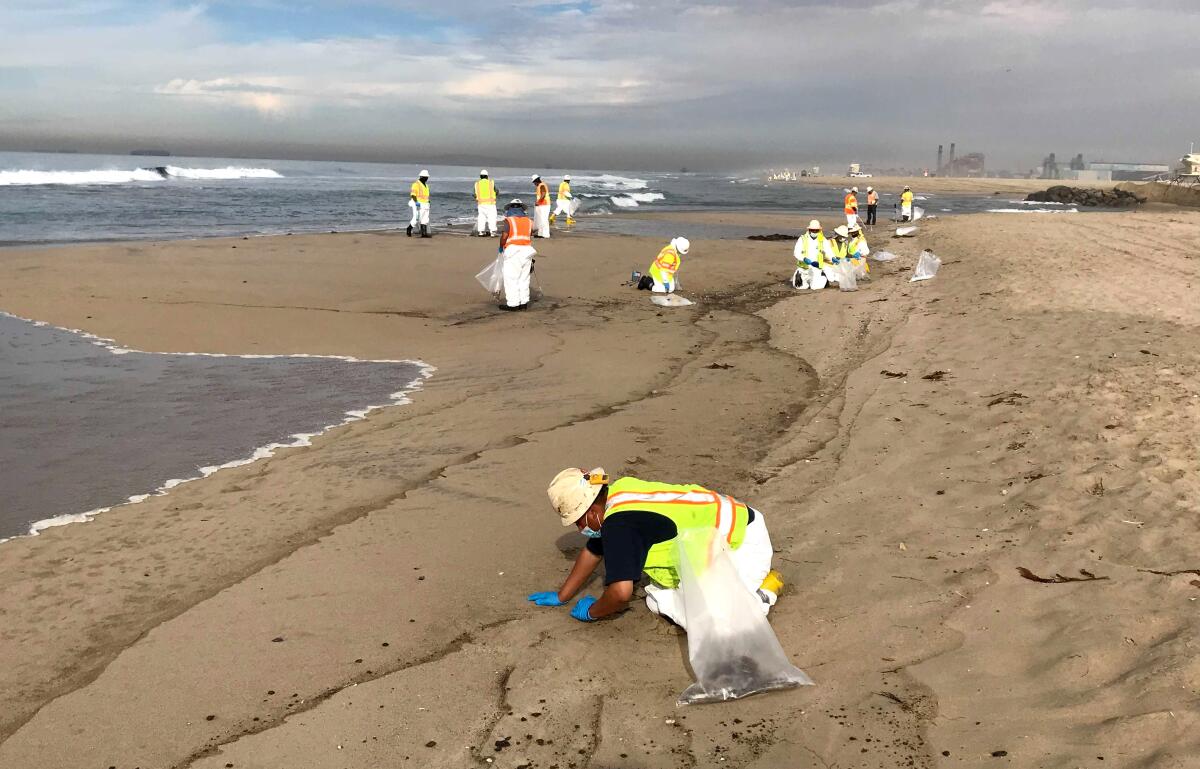 Beach cleanup at the Talbert channel entrance to Huntington State Beach after an oil spill.