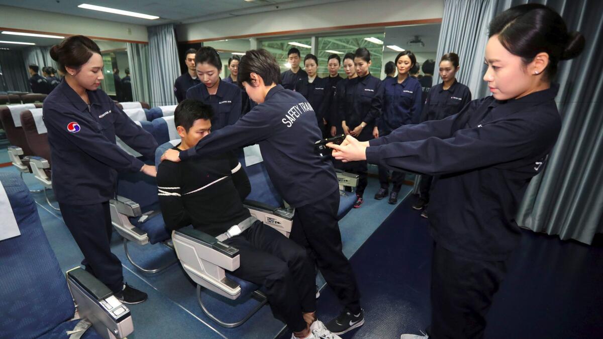 Crew members of Korean Air receive training in handling unruly passengers in a mock cabin in Seoul on Dec. 27, 2016.