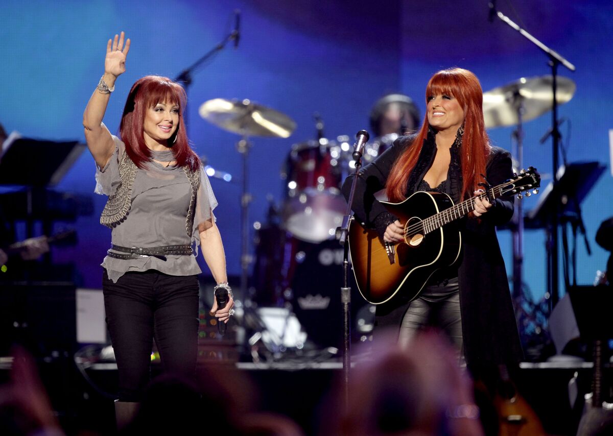 FILE - Naomi Judd, left, and Wynonna Judd, of The Judds, perform at the Girls' Night Out: Superstar Women of Country in Las Vegas on April 4, 2011. The Judds are reuniting to perform their song “Love Will Be A Bridge” on the CMT Music Awards, April 11 on CBS. (AP Photo/Julie Jacobson, File)