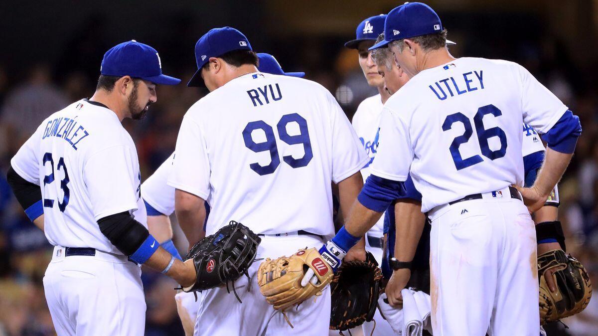 Dodgers pitcher Hyun-Jin Ryu gets a pat from Adrian Gonzalez, left, and Chase Utley while leaving the game with a 5-2 lead over the Miami Marlins in his last start, May 18.