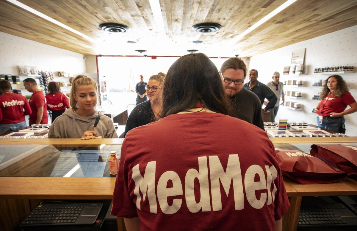 A MedMen employee helps customers.