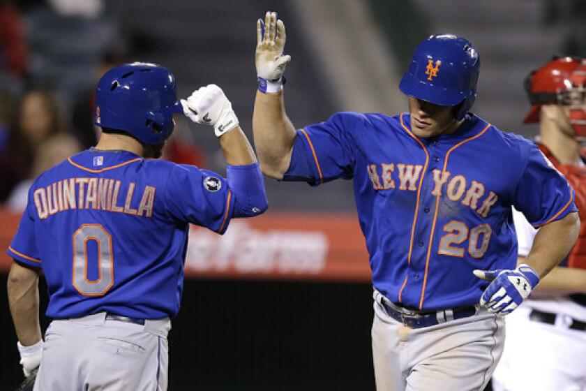 New York Mets' Anthony Recker, right, celebrates with teammate Omar Quintanilla after hitting a solo home run in the 13th inning of the Angels' 7-6 loss Saturday night.