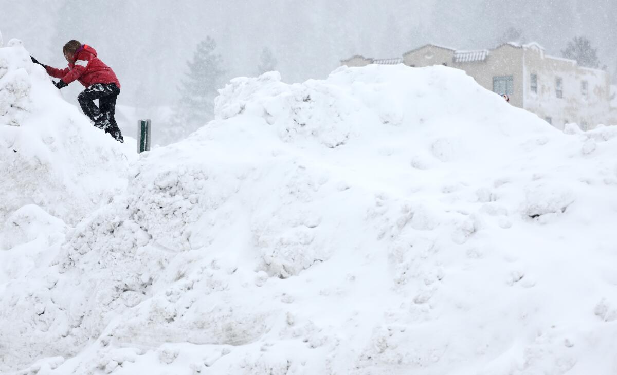 A child plays on a tall snowbank as snow falls north of Lake Tahoe.