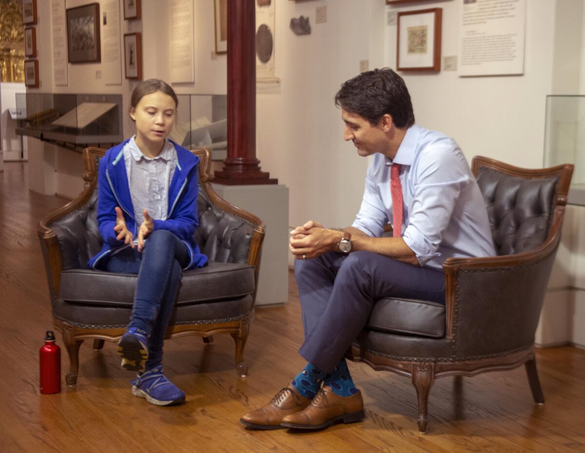 Canadian Prime Minister Justin Trudeau speaks with Swedish environmental activist Greta Thunberg. 