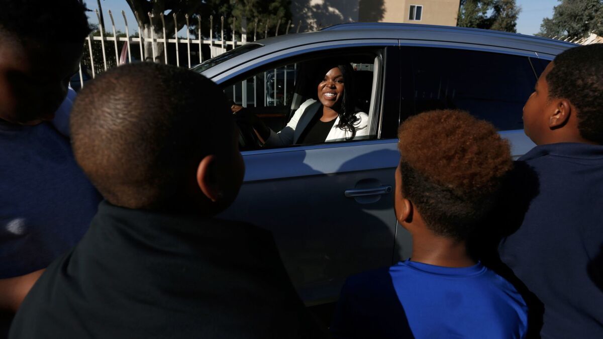 Compton Mayor Aja Brown greets neighborhood children outside of the Center for Sustainable Communities under construction in Compton.