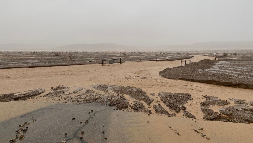 A road covered in muddy water and debris