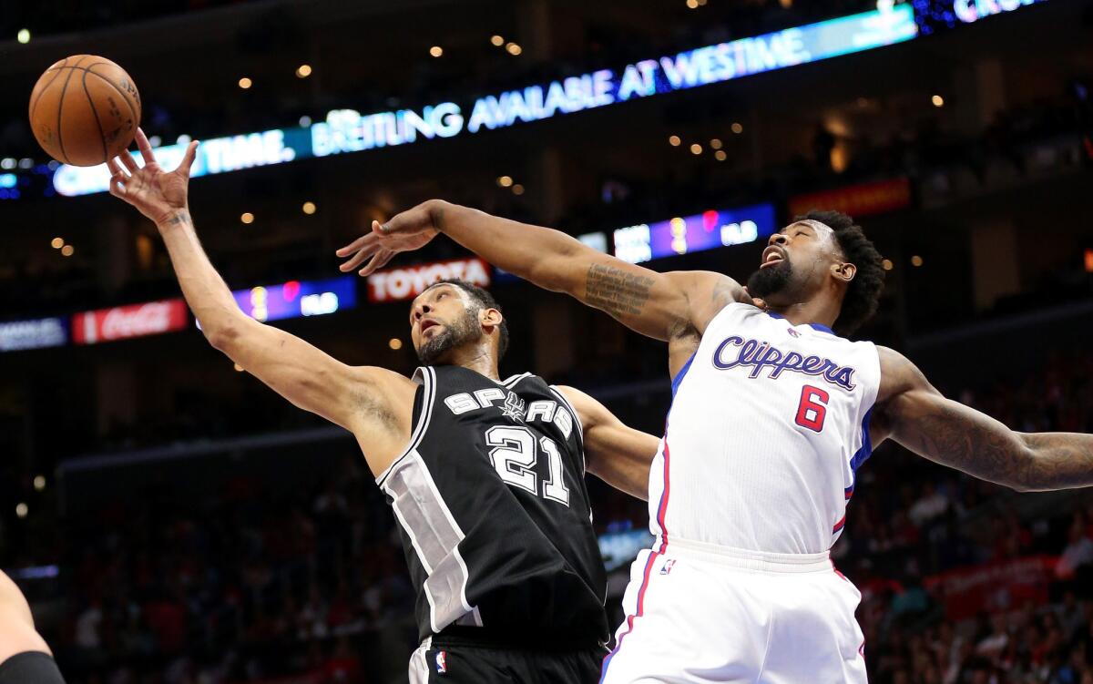 DeAndre Jordan and Spurs forward Tim Duncan chase a rebound during the Clippers' loss 111-107 to San Antonio in Game 5 of the playoff series.