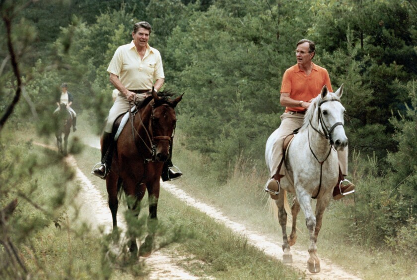 FILE - In this July 1981 file photo released by The White House, U.S. President Ronald Reagan, left, and Vice President George Bush go horseback riding at Camp David, Md. The compound in the Maryland mountains just 60 miles from the capital features everything from a bowling alley to an archery range. It’s been used by every president since Franklin Delano Roosevelt first went there in 1943 as a personal hideaway. (Michael Evans/The White House, via AP)