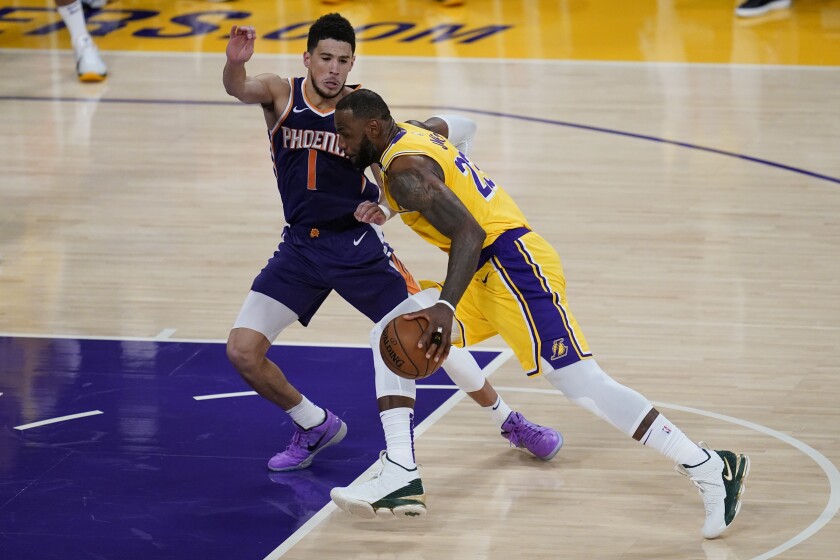 The Lakers' LeBron James drives against the Phoenix Suns' Devin Booker during Game 6 on June 3, 2021.