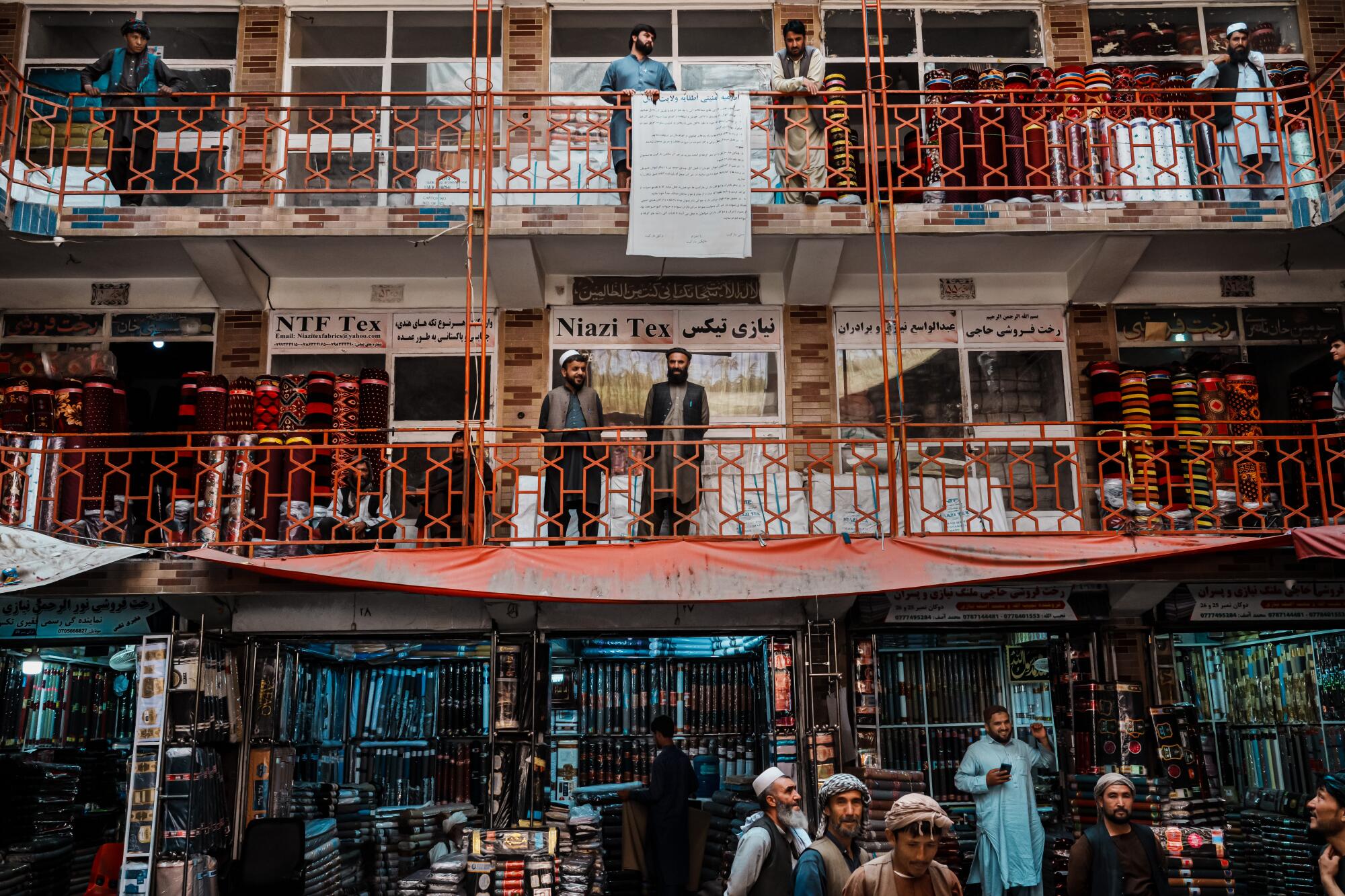 Carpet sellers outside their stores waiting for customers