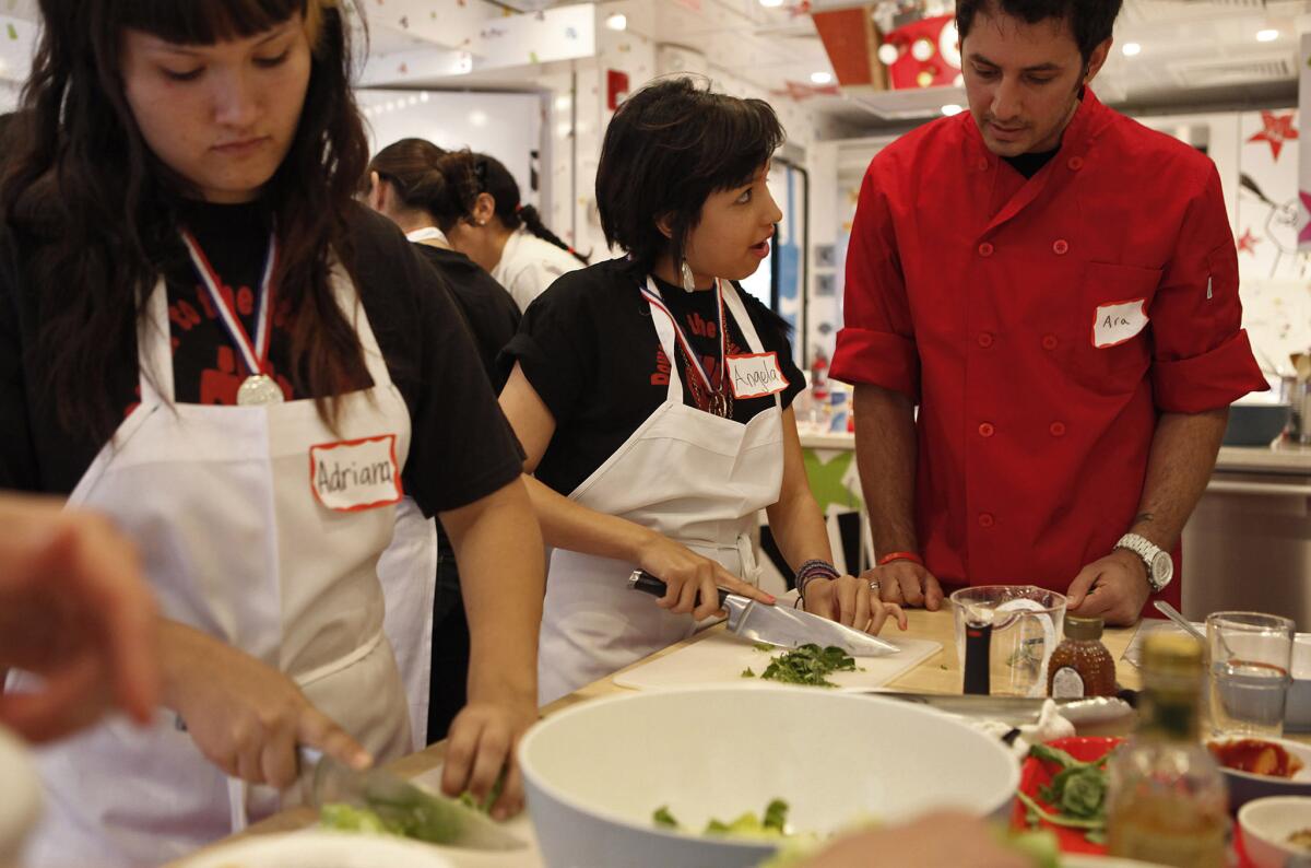 Teacher Ara Berberian supervises students Angela Gonzales and Adrian Valenzuela, both 16, during a class in Jamie Oliver's Big Rig Cooking School in 2011.