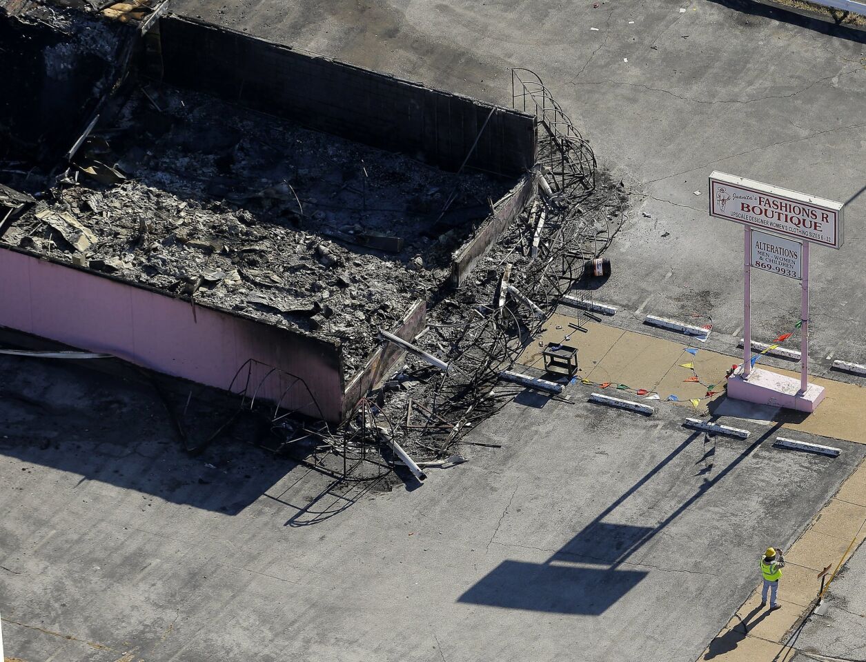 In this aerial photo, a worker surveys the scene at a charred building in Ferguson, Mo.