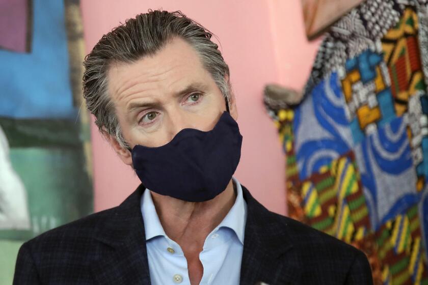 FILE - In this June 9, 2020, file photo, California Gov. Gavin Newsom wears a protective mask on his face while speaking to reporters at Miss Ollie's restaurant during the coronavirus outbreak in Oakland, Calif. According to a new poll, Americans overwhelmingly are in favor of requiring people to wear masks around other people outside their homes, reflecting fresh alarm over spiking infection rates. The poll also shows increasing disapproval of the federal government's response to the pandemic. California is among the states seeing the greatest surge in cases now. (AP Photo/Jeff Chiu, Pool, File)