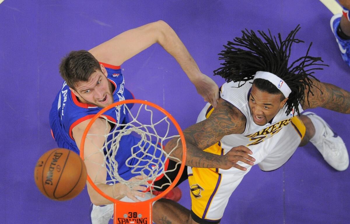 Philadelphia 76ers center Spencer Hawes, left, and Lakers center Jordan Hill battle for a rebound during the first half of Sunday's game at Staples Center.