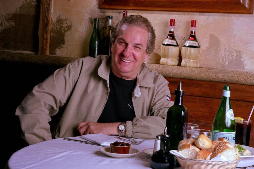 FILE - In this July 28, 2001 file photo, Danny Aiello poses for a photo at Gigino restaurant in New York. Aiello, the blue-collar character actor whose long career playing tough guys included roles in “Fort Apache, the Bronx,” "The Godfather, Part II," “Once Upon a Time in America” and his Oscar-nominated performance as a pizza man in Spike Lee’s "Do the Right Thing," has died. He was 86. Aiello died Thursday, Dec. 12, 2019 after a brief illness, said his publicist, Tracey Miller. (AP Photo/Jim Cooper, File)