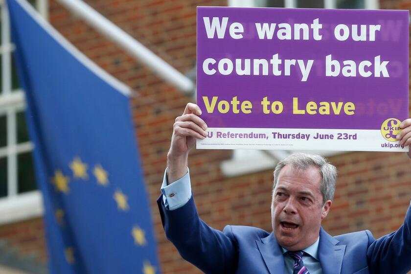 British politician and leader of the UKIP party Nigel Farage holds up a placard in support of Brexit.