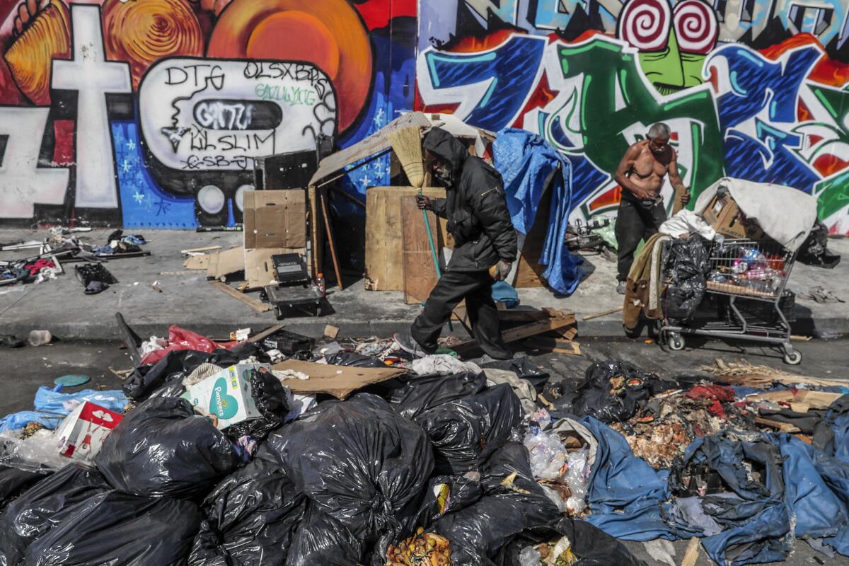 Piles of trash remain at the corner of East 10th Street and Naomi Avenue in downtown Los Angeles.
