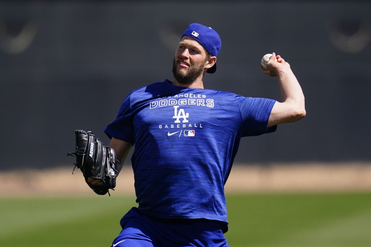 Los Angeles Dodgers pitcher Clayton Kershaw warms up during a spring training baseball workout Sunday, March 13, 2022, in Phoenix. (AP Photo/Ross D. Franklin)
