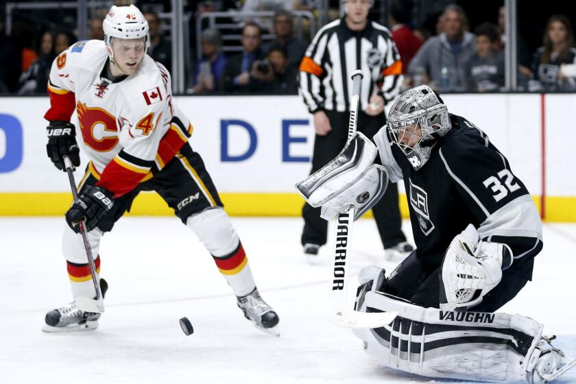 Kings goalie Jonathan Quick makes a save in front of Flames center Hunter Shinkaruk during a game March 31.