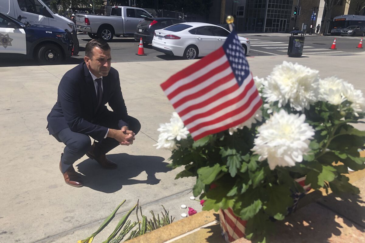 FILE - In this May 27, 2021, file photo, San Jose Mayor Sam Liccardo stops to view a makeshift memorial for the rail yard shooting victims in front of City Hall in San Jose, Calif. San Jose officials passed a new gun law, that requires gun owners to carry liability insurance and pay a fee to cover taxpayers' cost associated with gun violence. The City Council unanimously approved the new law Tuesday, June 29, 2021, less than a month after a disgruntled employee fatally shot nine of his co-workers and then himself at a rail yard in San Jose, according to police. (AP Photo/Haven Daley, File)