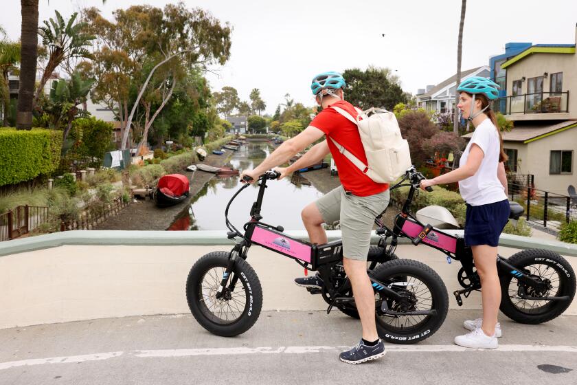 VENICE-CA-MAY 31, 2024: A pair of tourists visit the Venice Canals on May 31, 2024. (Christina House / Los Angeles Times)