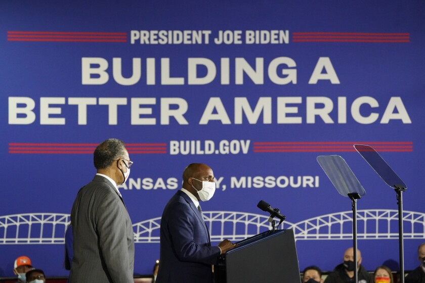 Kansas City, Mo., Mayor Quinton Lucas speaks as Rep. Emanuel Cleaver, D-Mo., listens before President Joe Biden speaks about broadband, road and other infrastructure projects during an event at the Kansas City Area Transit Authority, Wednesday, Dec. 8, 2021, in Kansas City, Mo. (AP Photo/Alex Brandon)