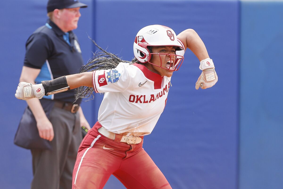Oklahoma's Rylie Boone (0) celebrates at home plate after hitting a home run in the third inning of an NCAA softball Women's College World Series game against Northwestern on Thursday, June 2, 2022, in Oklahoma City. (AP Photo/Alonzo Adams)