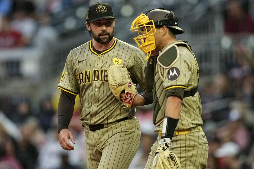 San Diego Padres pitcher Matt Waldron (61) Kyle Higashioka (20) speak on the mound in the second inning of a baseball game against the Atlanta Braves, Friday, May 17, 2024, in Atlanta. (AP Photo/Mike Stewart)