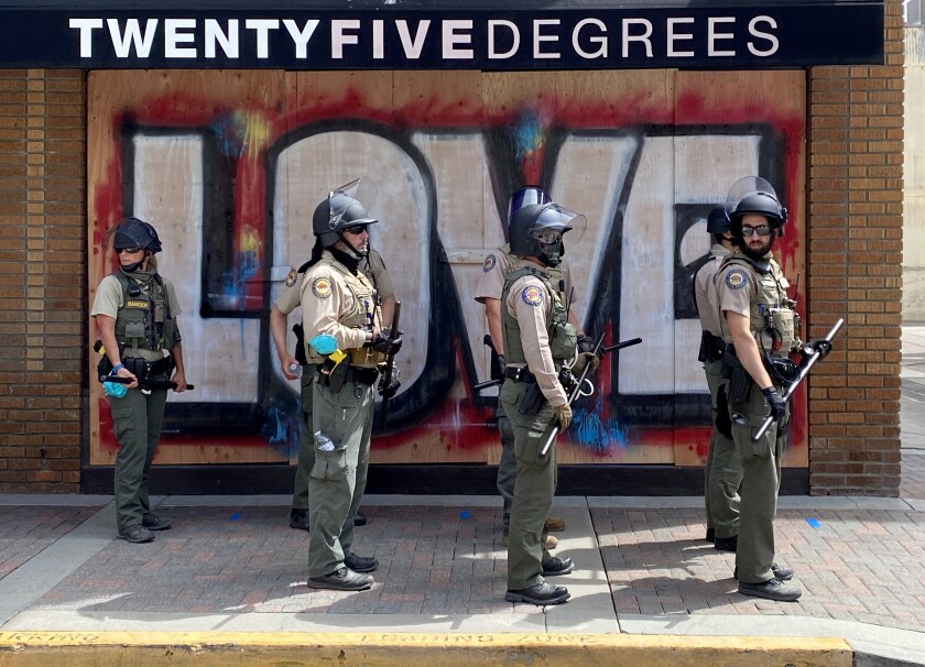 California State Parks officers help local police patrol the area in Huntington Beach in June.