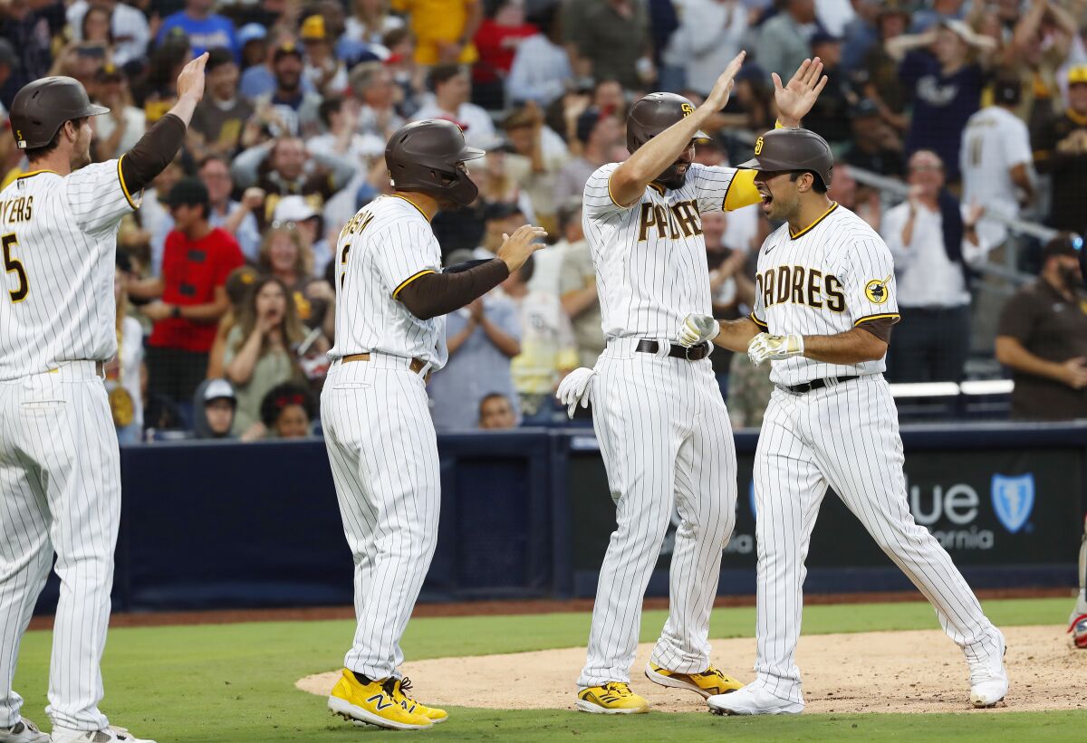 Padres' Daniel Camarena (right) celebrates with teammates after hitting a grand slam Thursday at Petco Park.