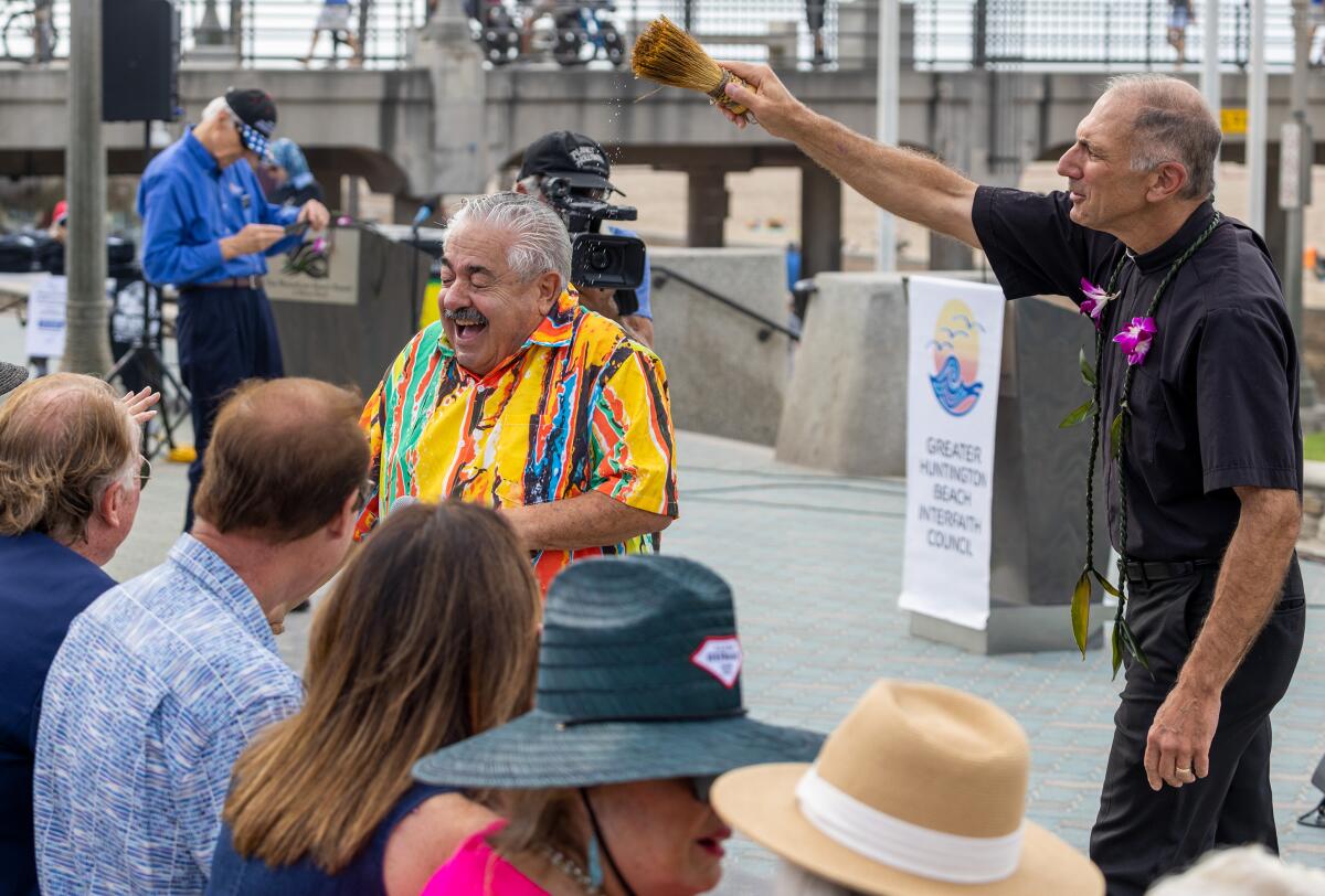 Father Mike Rizzon of Saints Simon & Jude Catholic Church performs a blessing ceremony including Dave Garofalo, right.