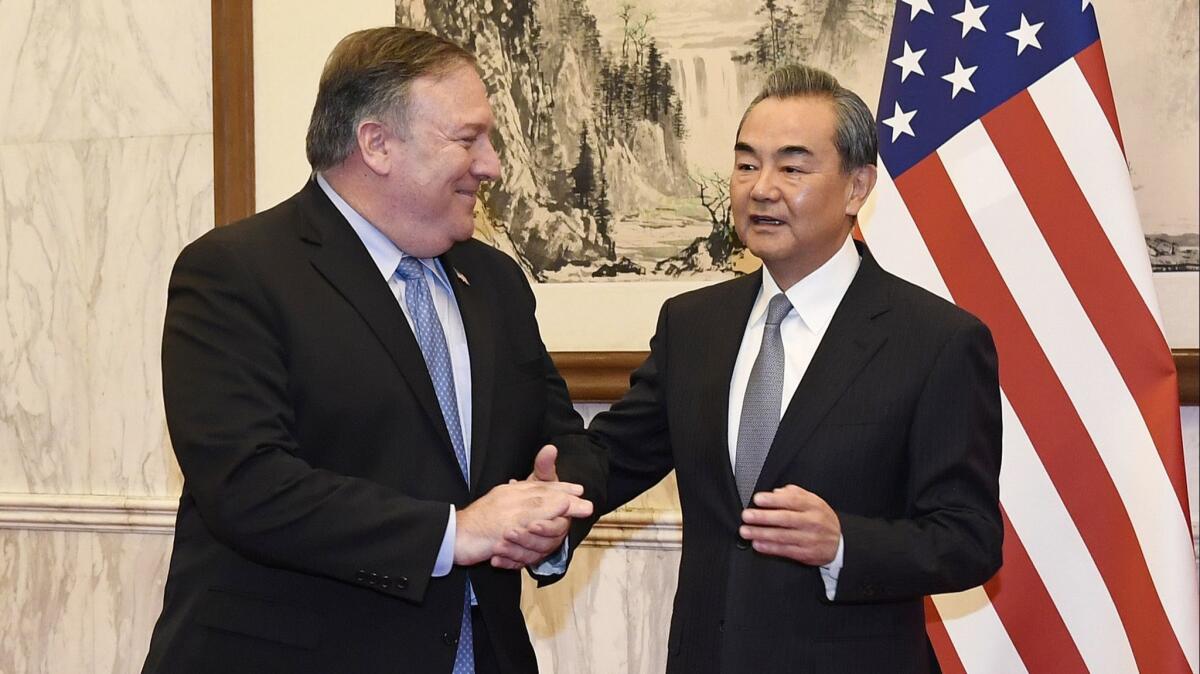 Chinese Foreign Minister Wang Yi, right, greets U.S. Secretary of State Michael R. Pompeo before a meeting at the Diaoyutai State Guesthouse on Monday, Oct. 8, 2018, in Beijing.