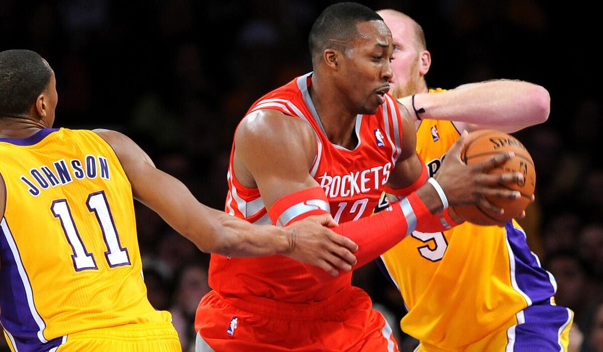 Houston Rockets center Dwight Howard tries to drive between Lakers forward Wesley Johnson and center Chris Kaman during a Feb. 18 game at Staples Center.