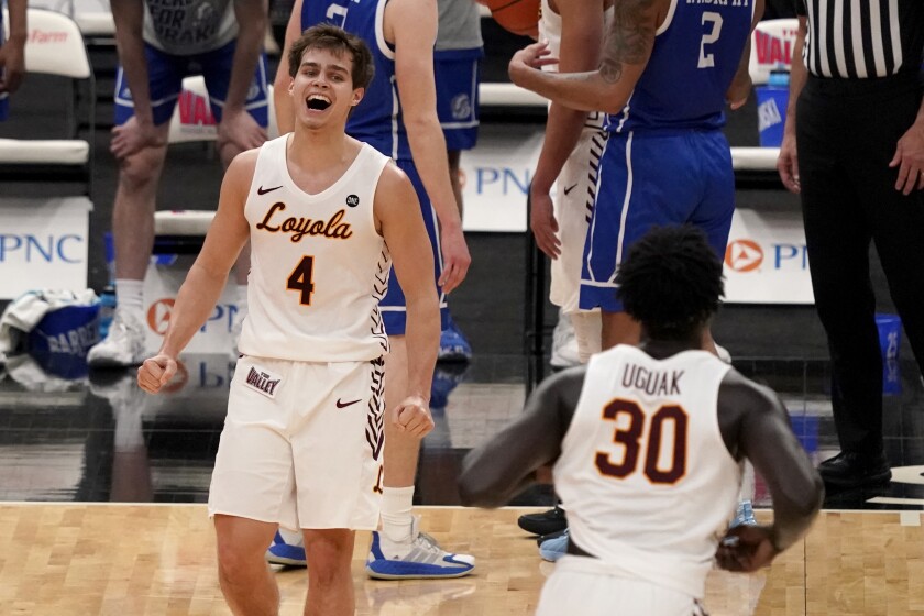 Loyola of Chicago's Braden Norris (4) and teammate Aher Uguak (30) celebrate a 75-65 victory over Drake during the championship game in the NCAA Missouri Valley Conference men's basketball tournament Sunday, March 7, 2021, in St. Louis. (AP Photo/Jeff Roberson)