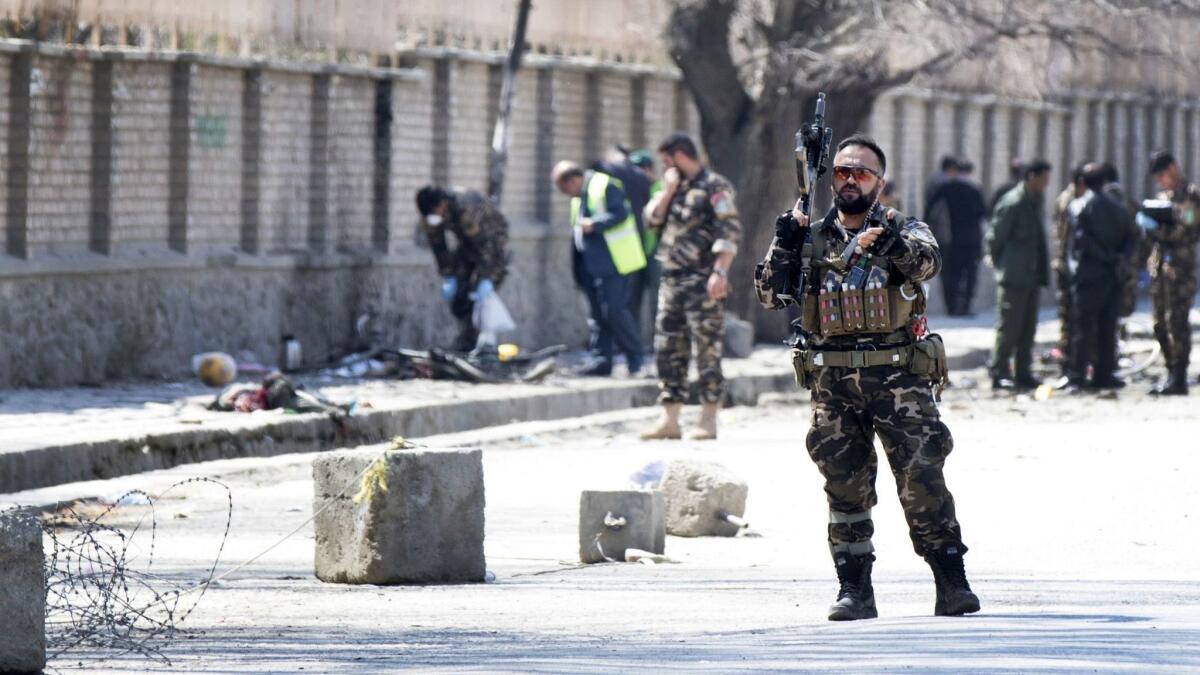 Security officials inspect the scene of a suicide bomb blast on March 21, 2018, that targeted a shrine visited by Shiite Muslims in Kabul, Afghanistan, as the country observes Nowruz, the Persian New Year.